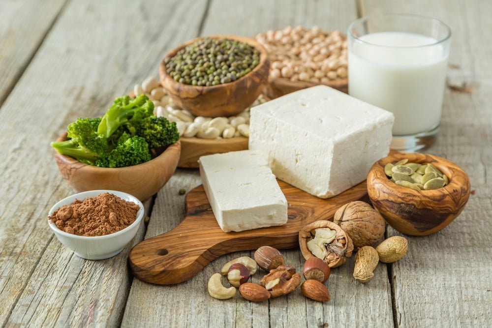 Verschillende eiwitrijke voedingsmiddelen zoals tofu, peulvruchten, noten en melk